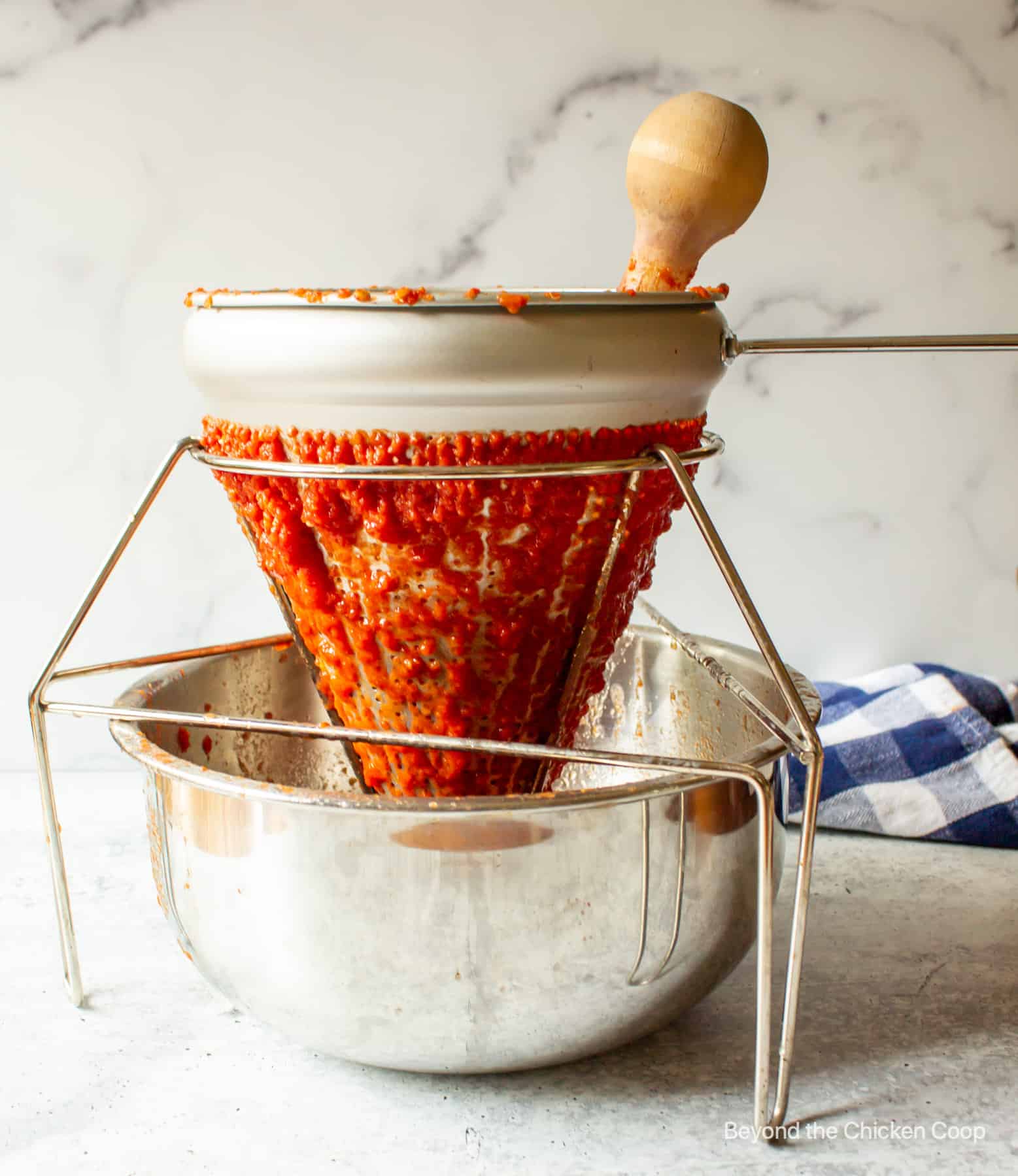 A chinois strainer filled with tomatoes.