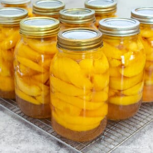 Glass jars filled with sliced peaches.