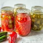 Canning jars filled with pickled jalapeno peppers.