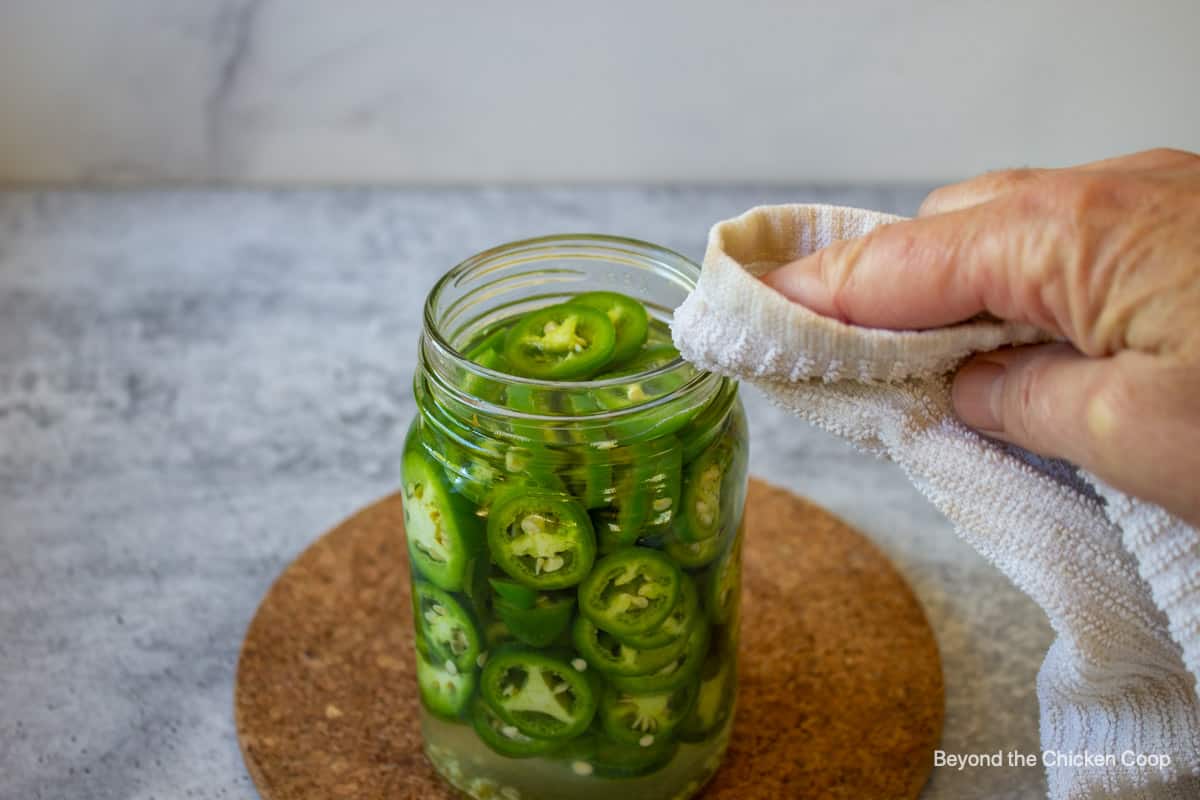 Wiping down the rim of a canning jar.