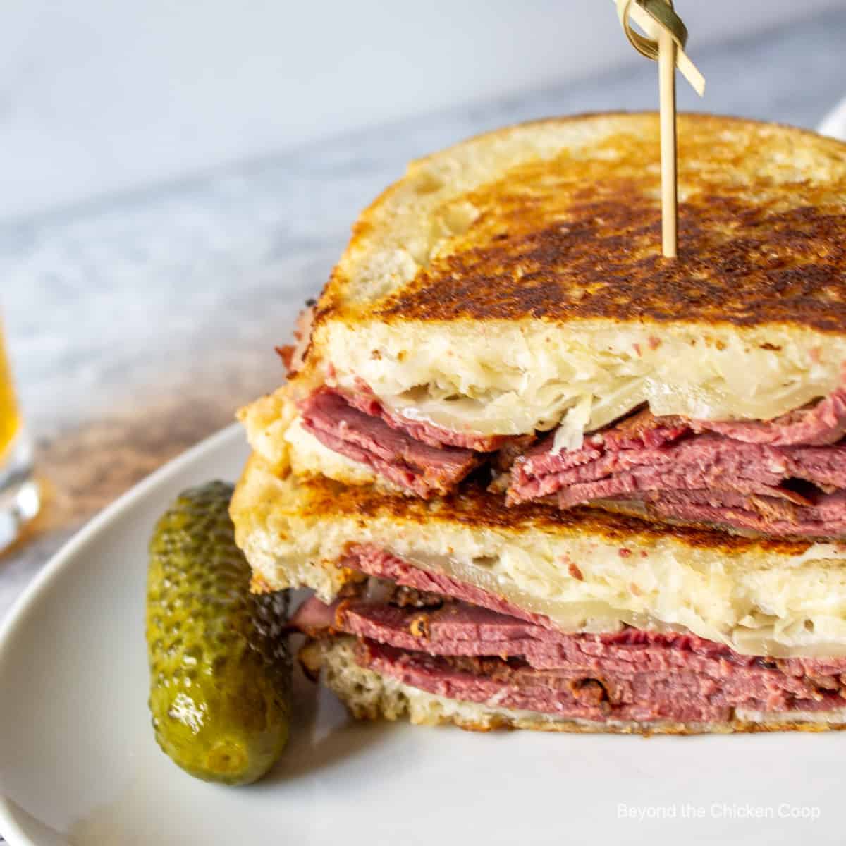 A toasted sandwich with pastrami, sauerkraut and cheese.