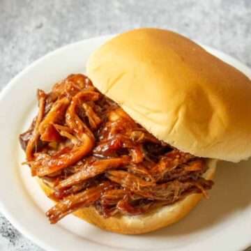 A hamburger bun filled with barbecued pulled pork.