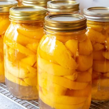 Quart sized jars filled with sliced peaches.