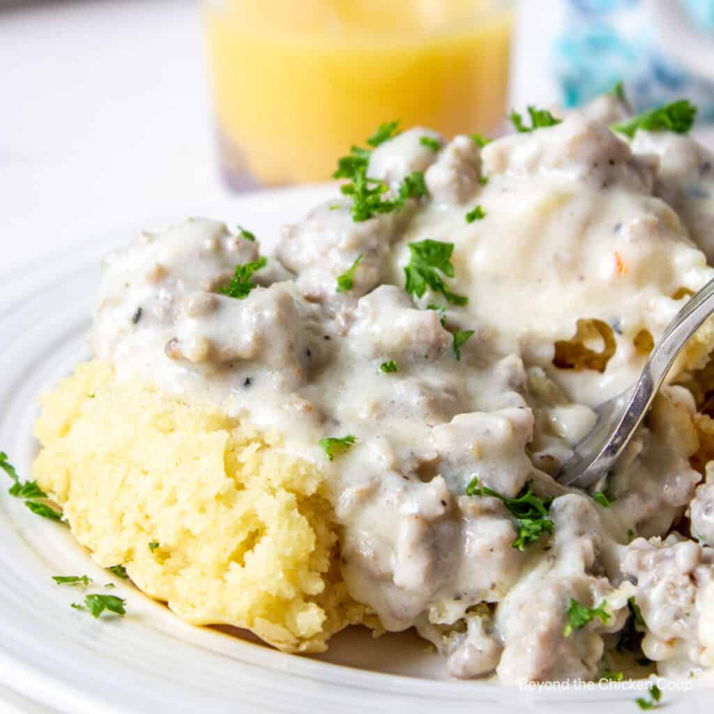 Biscuits and gravy topped with fresh parsley.