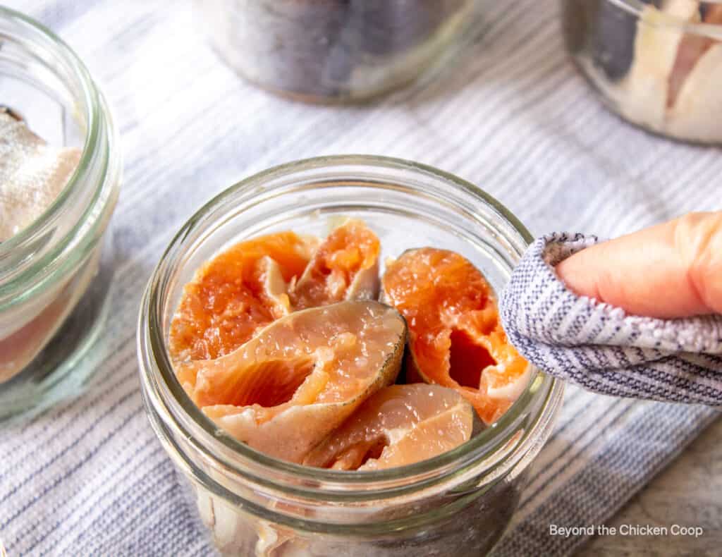 Wiping the rim of a canning jar.