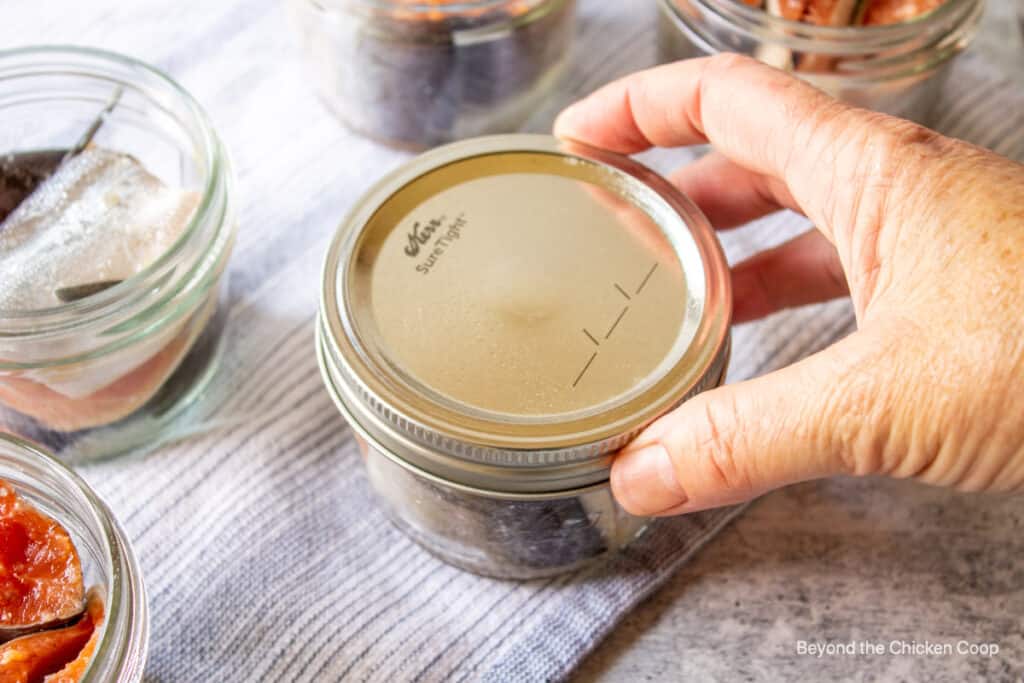 Placing a ring on a canning jar.