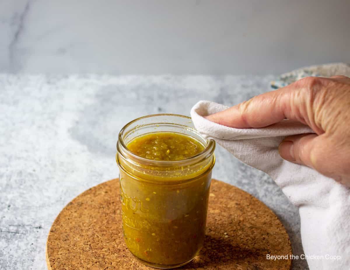 Wiping the rim of a canning jar.