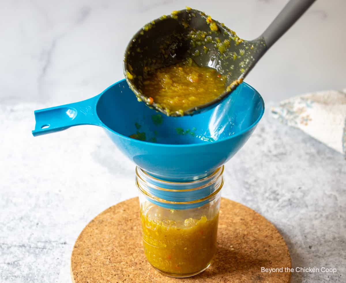 Ladling a relish into a canning jar.