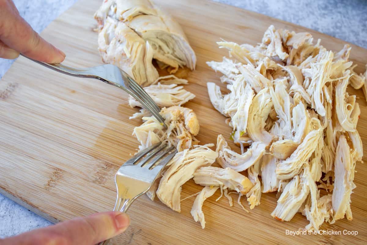 Shredded chicken on a cutting board.