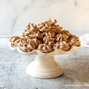 A cake stand filled with small meringue cookies.