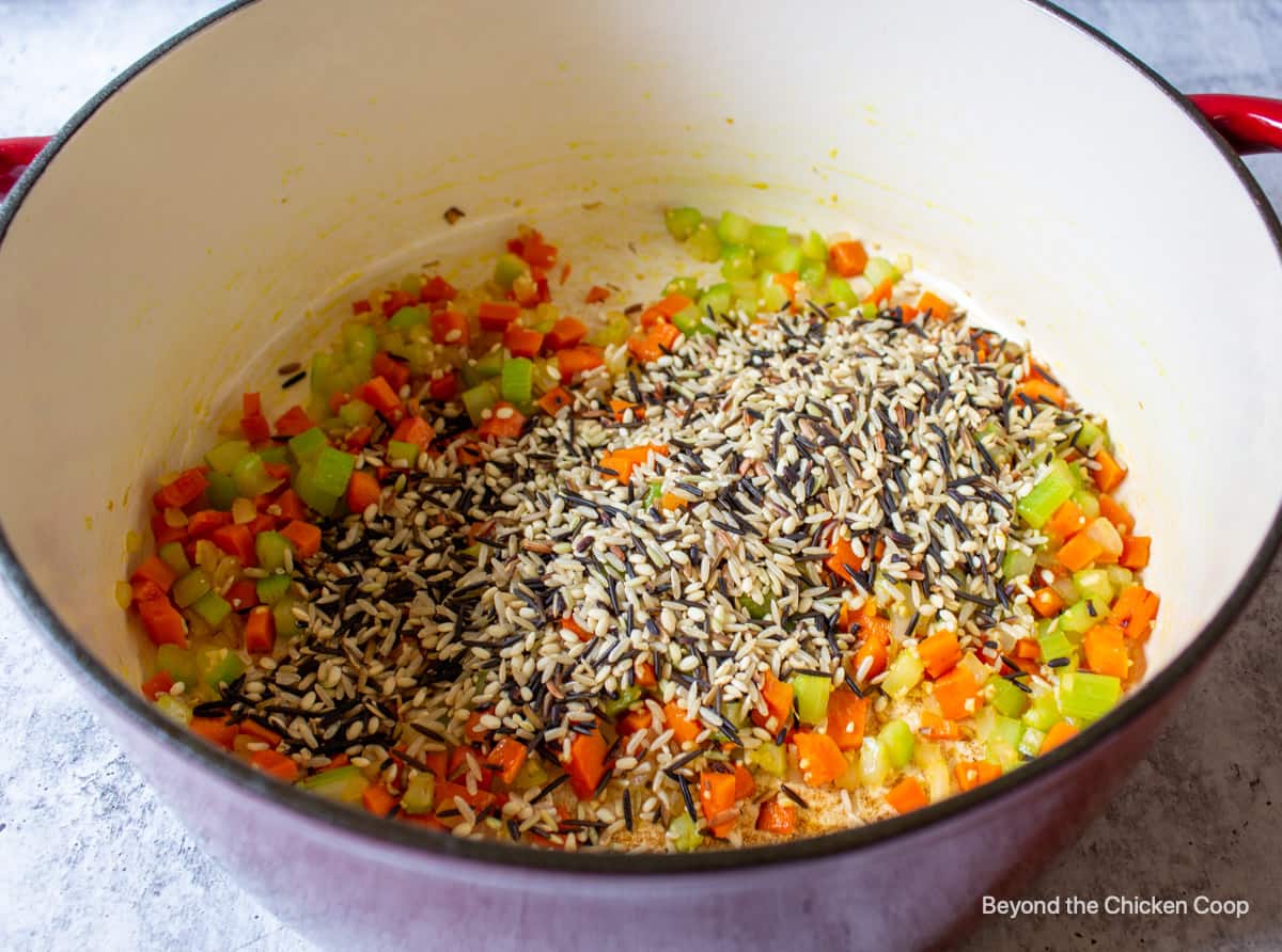 Wild rice added to a soup pot.