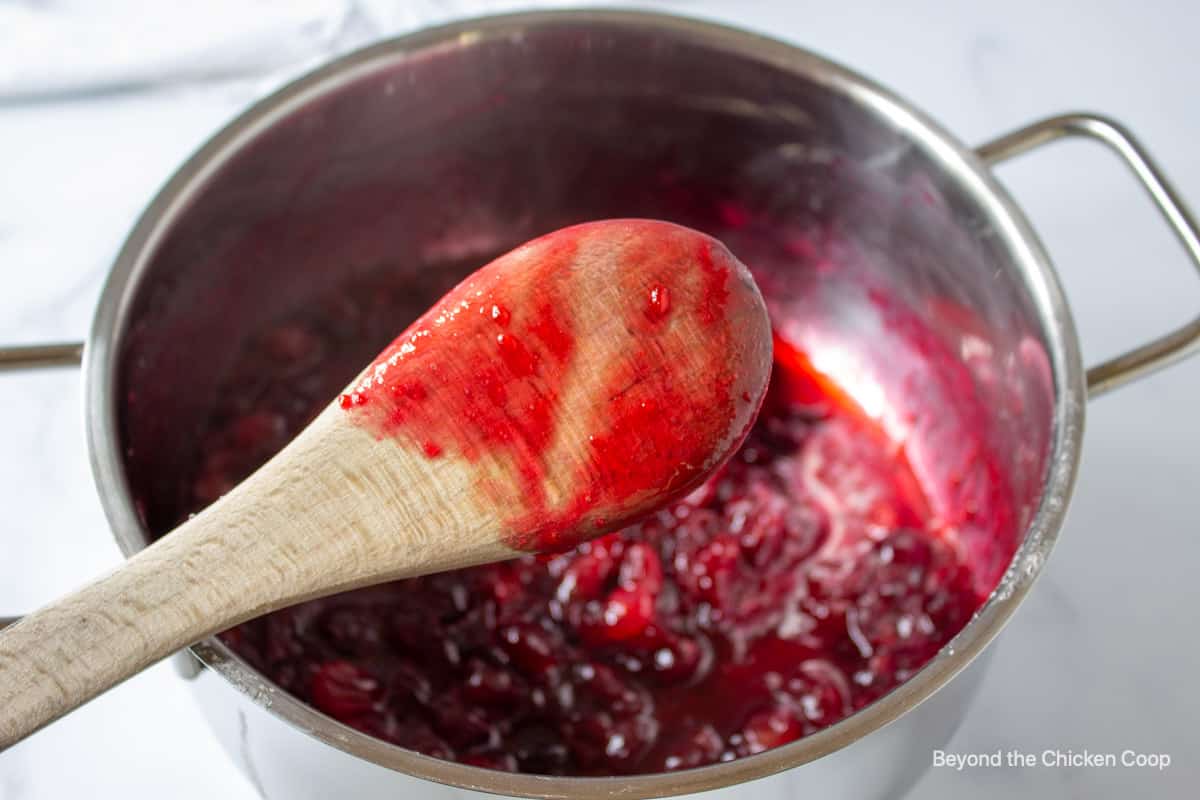 A wooden spoon covered with a red sauce.