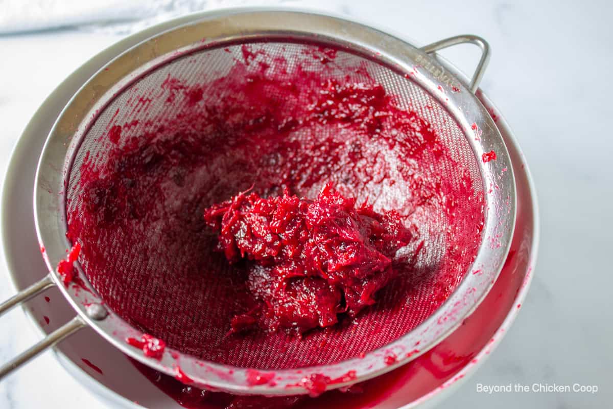 Strained cranberries with seeds left in a sieve.