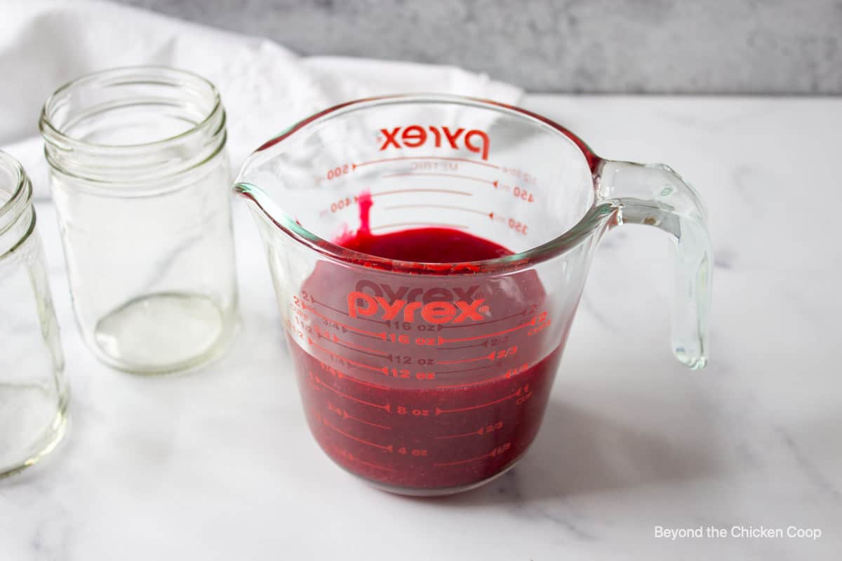 Cranberry sauce in a glass measuring cup.