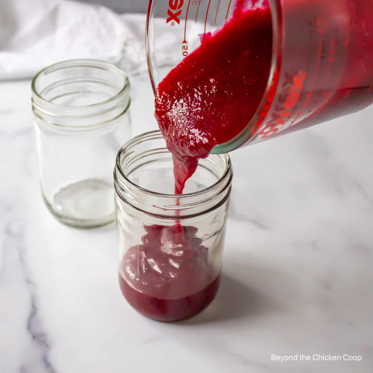 Pouring sauce into a jelly jar.