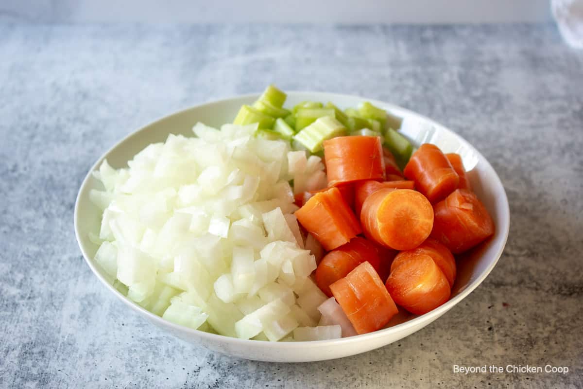 Carrots, onions and celery in a bowl.