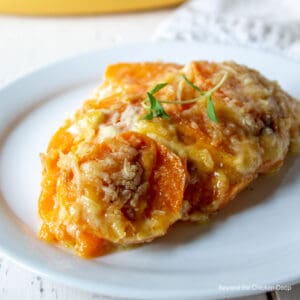 A portion of sweet potatoes topped with fresh thyme.