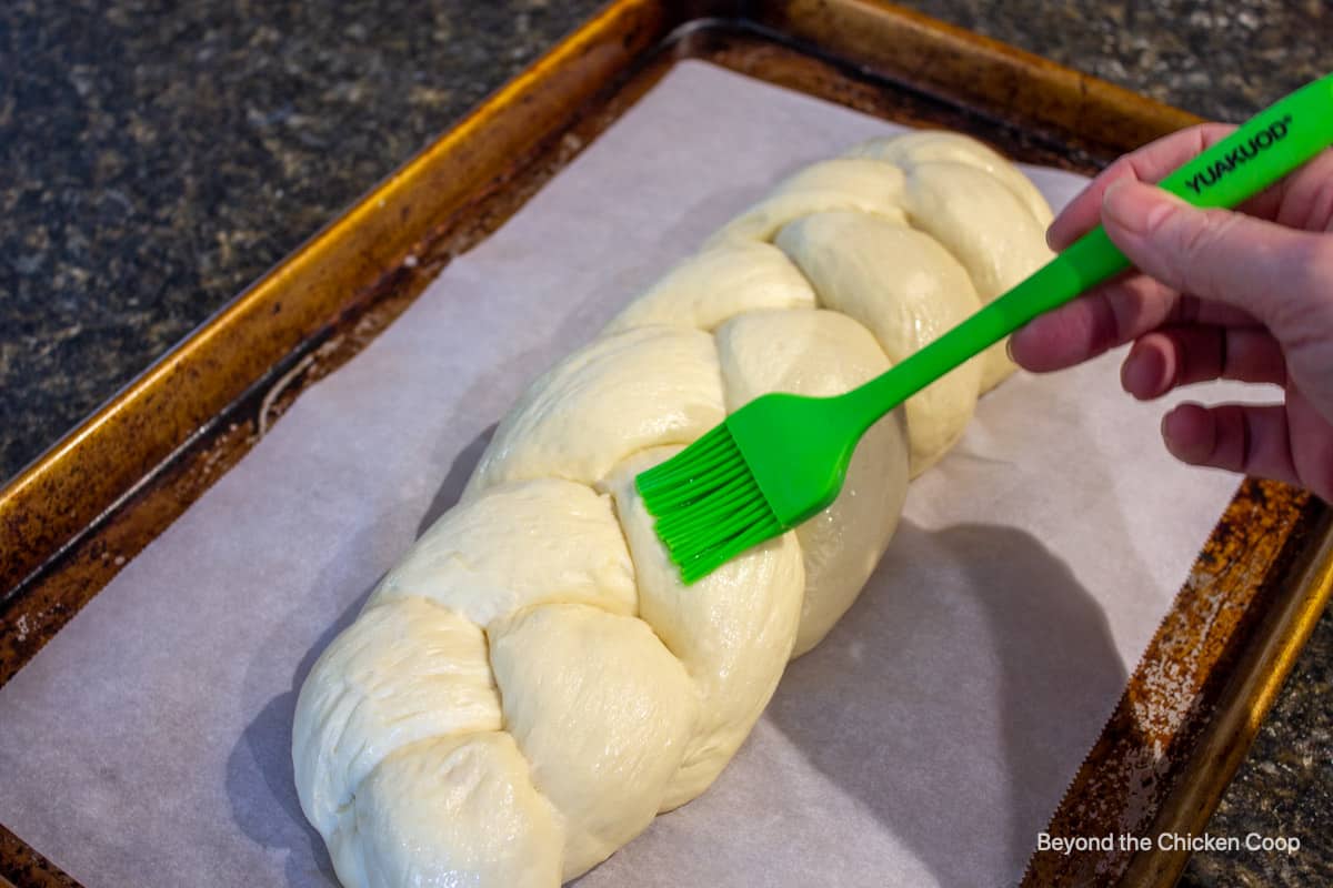 Brushing an egg wash on bread dough.