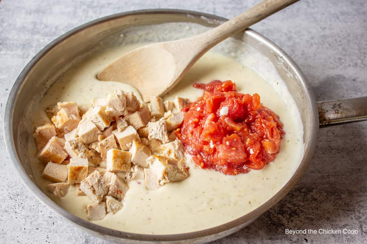 Chunks of chicken and diced tomatoes added to a creamy sauce.