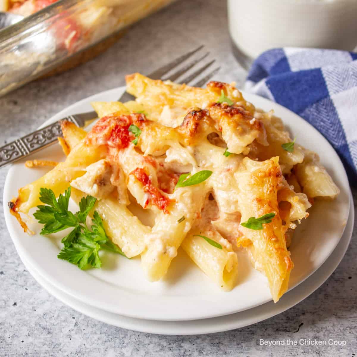 A portion of chicken pasta bake on a white plate. 
