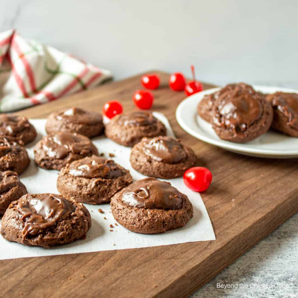 Chocolate cookies with frosting on a wooden board.