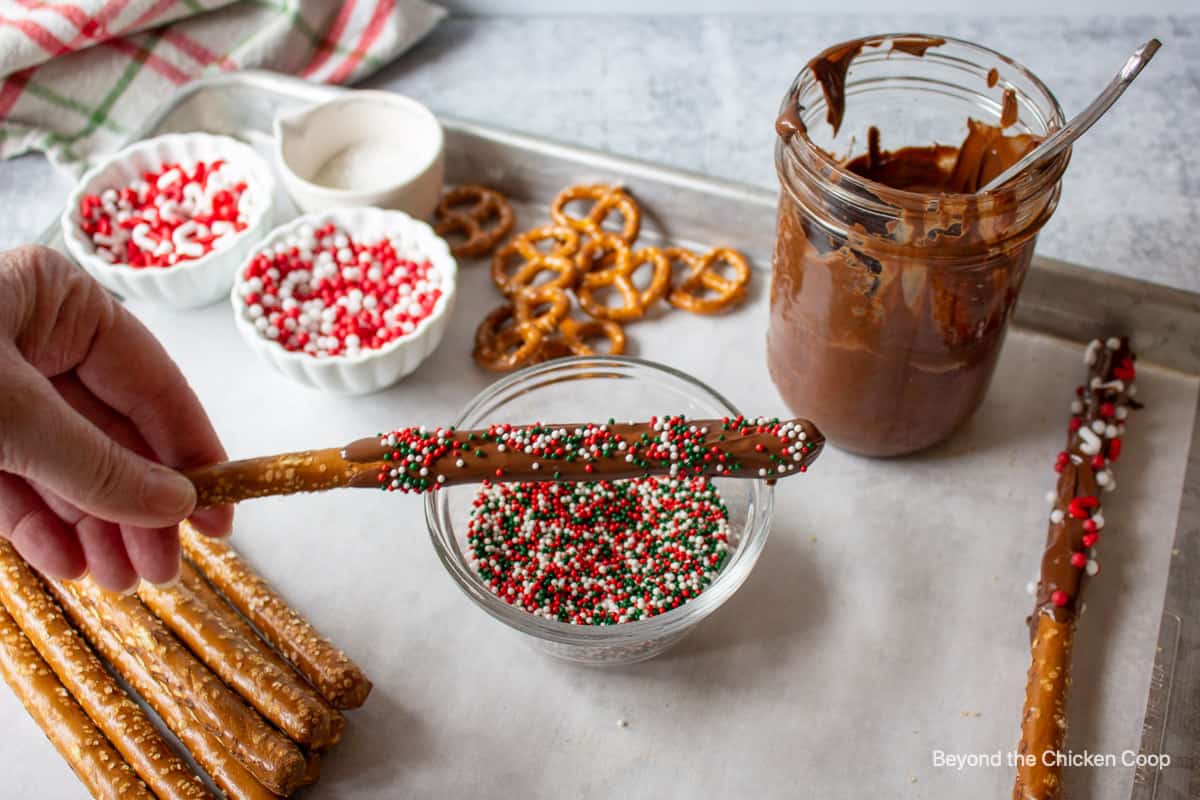 Sprinkles added to a chocolate pretzel.