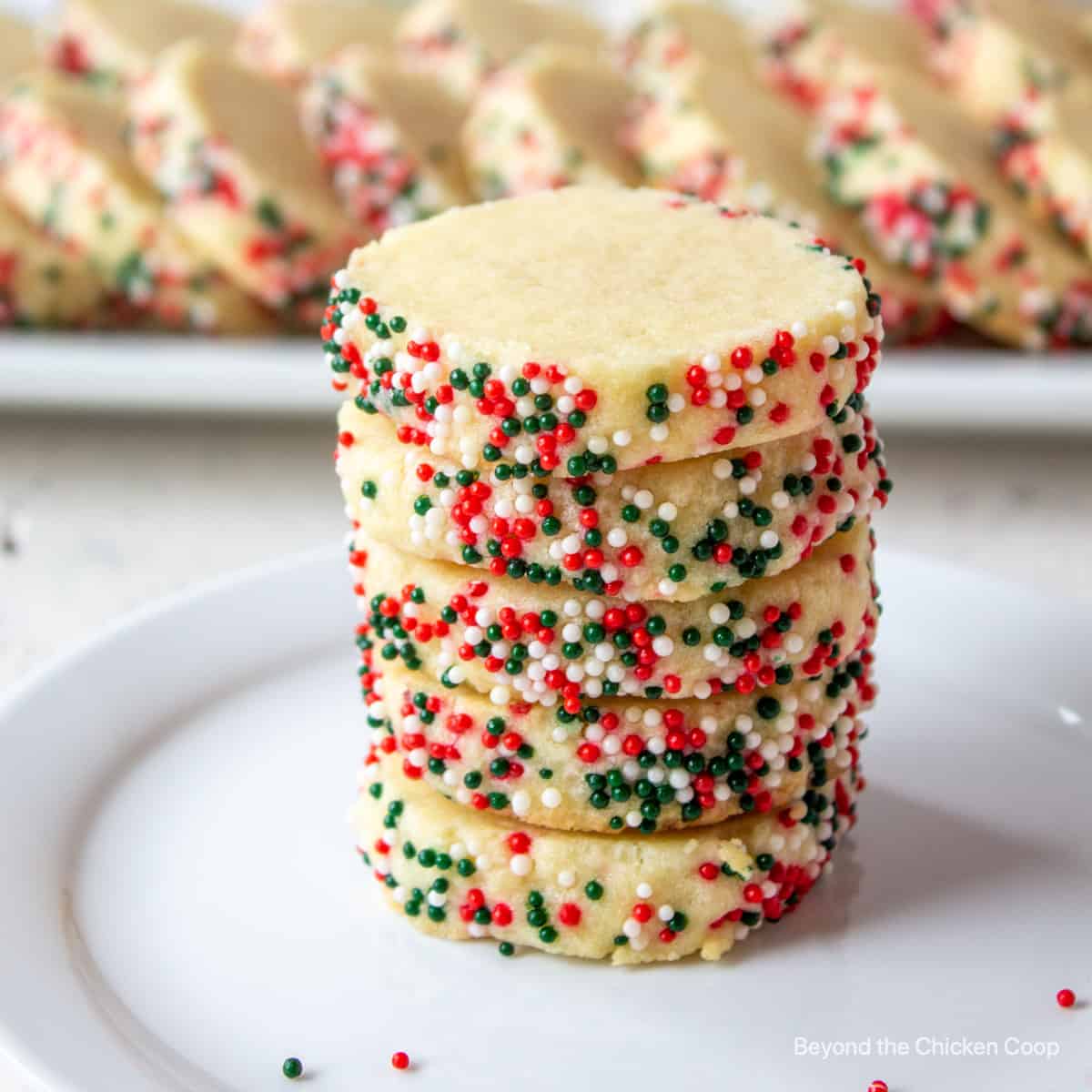 A stack of round cookies covered with colorful sprinkles.