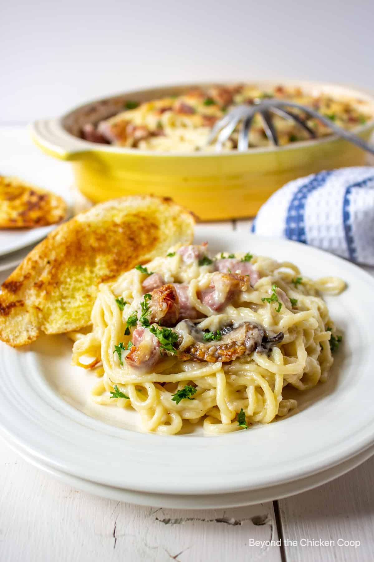 Spaghetti with ham and mushrooms on a plate.