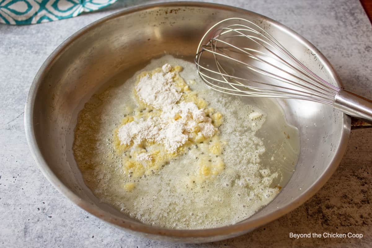 A saute pan with butter, garlic and flour.