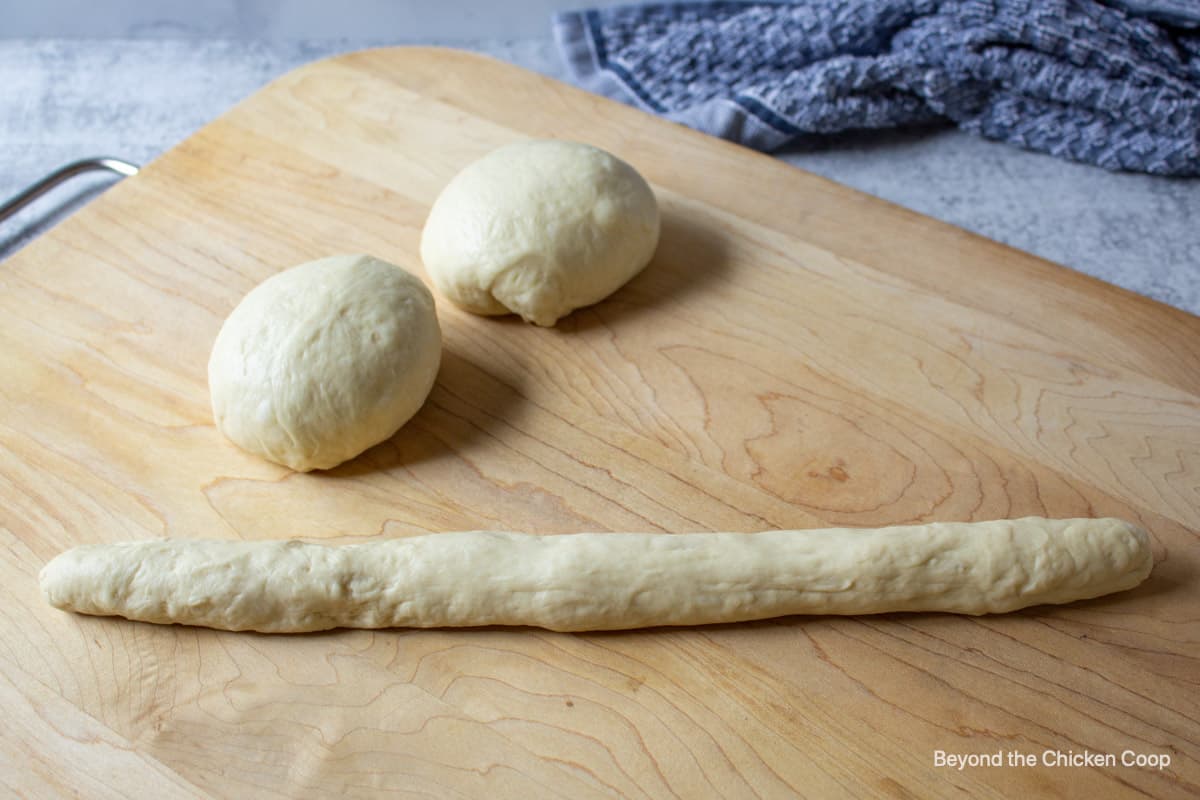Bread dough in round balls and formed into a long log.