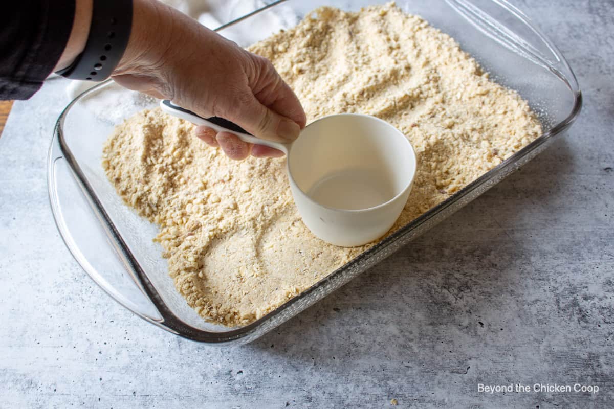 Pushing down a crust into a baking dish.