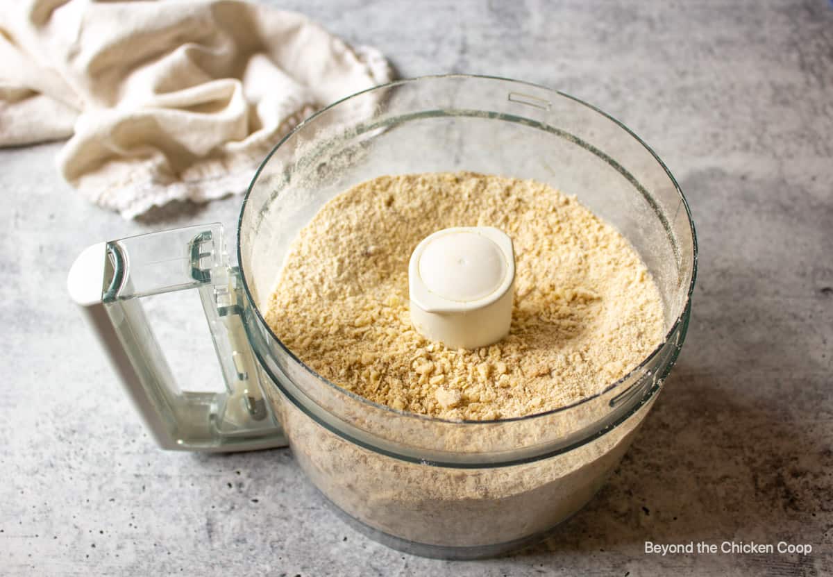 A dry crust mixture in a food processor bowl.