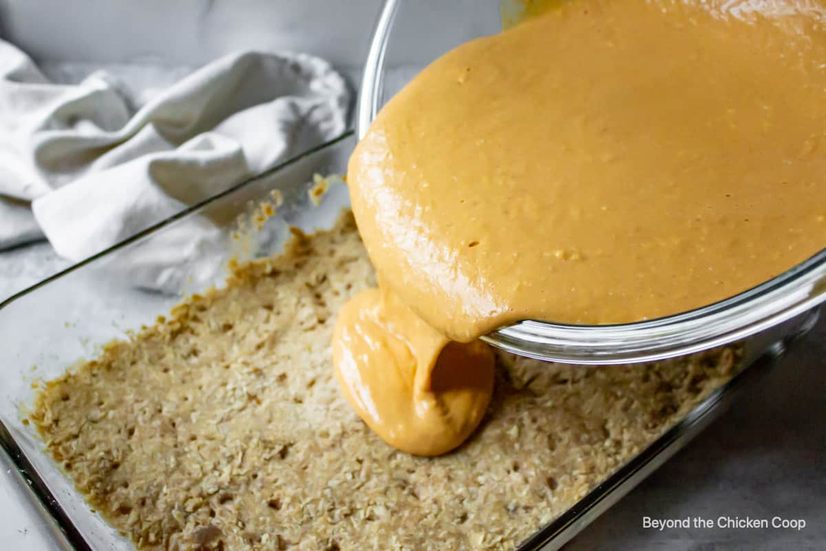 Pumpkin filling being poured over a baked crust.