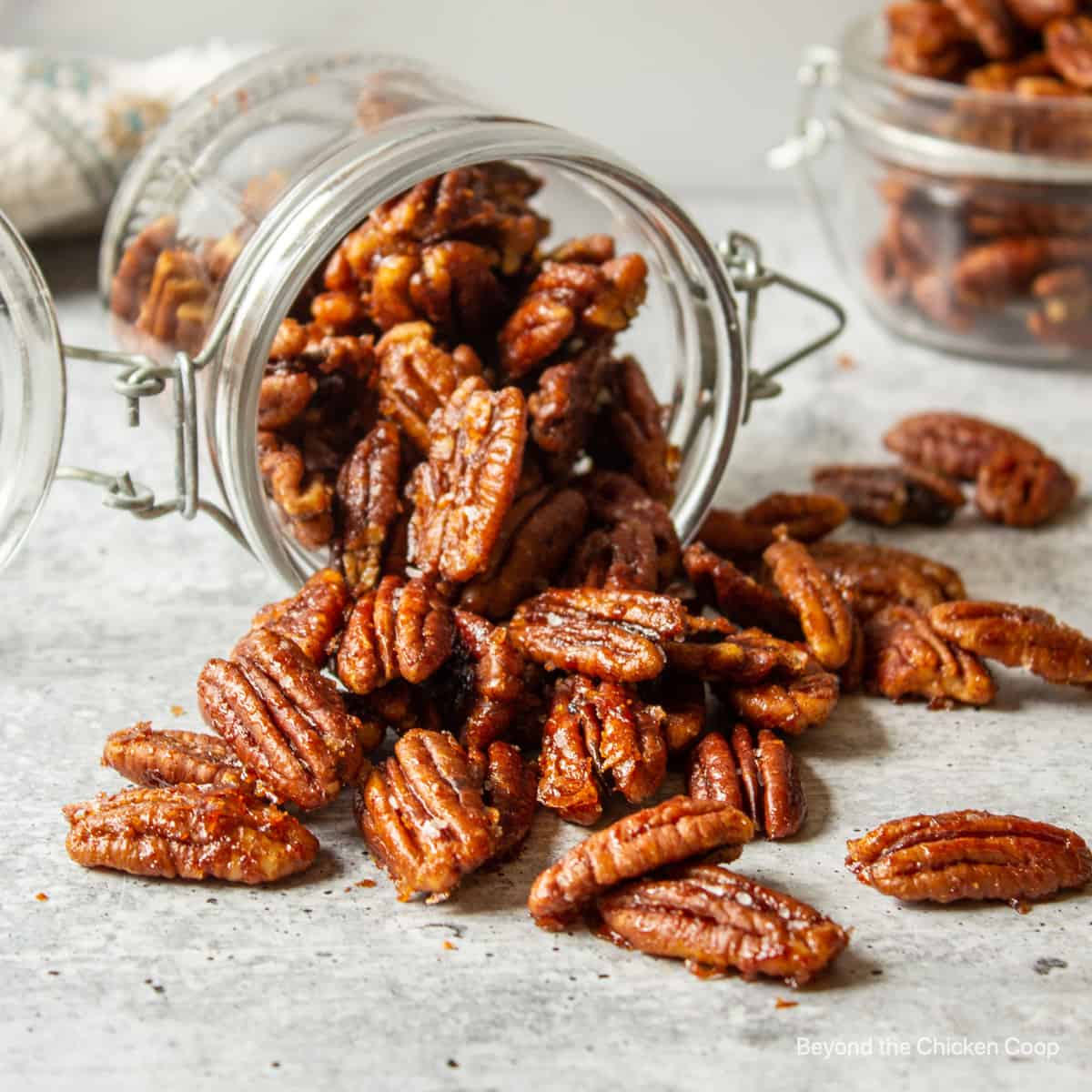 Spiced Pecans spilling out of a jar.