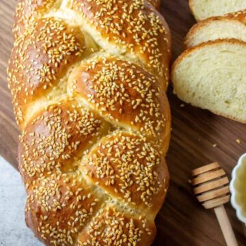A loaf of braided bread topped with sesame seeds.