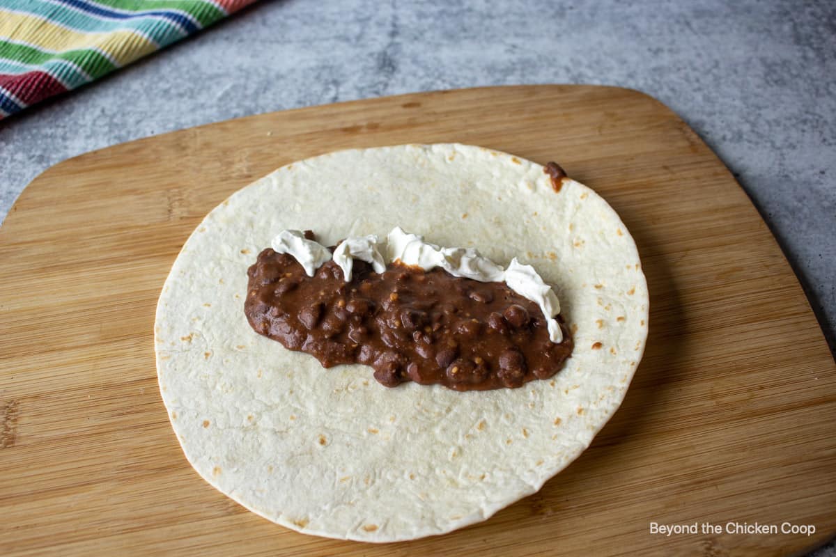 Beans and sour cream on a tortilla.