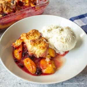 A cobbler with sliced peaches and blackberries.