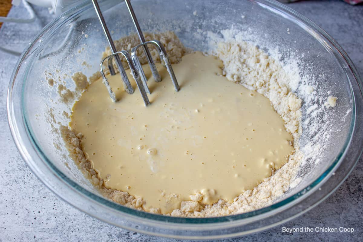 Mixing liquids into a flour mixture.