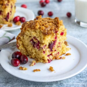 A slice of cranberry coffee cake on a small plate.