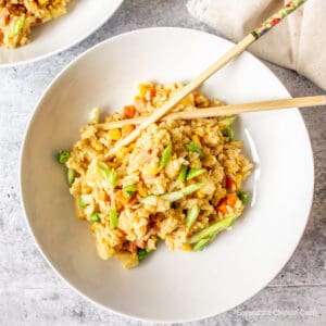 Fried rice in a bowl with chopsticks.