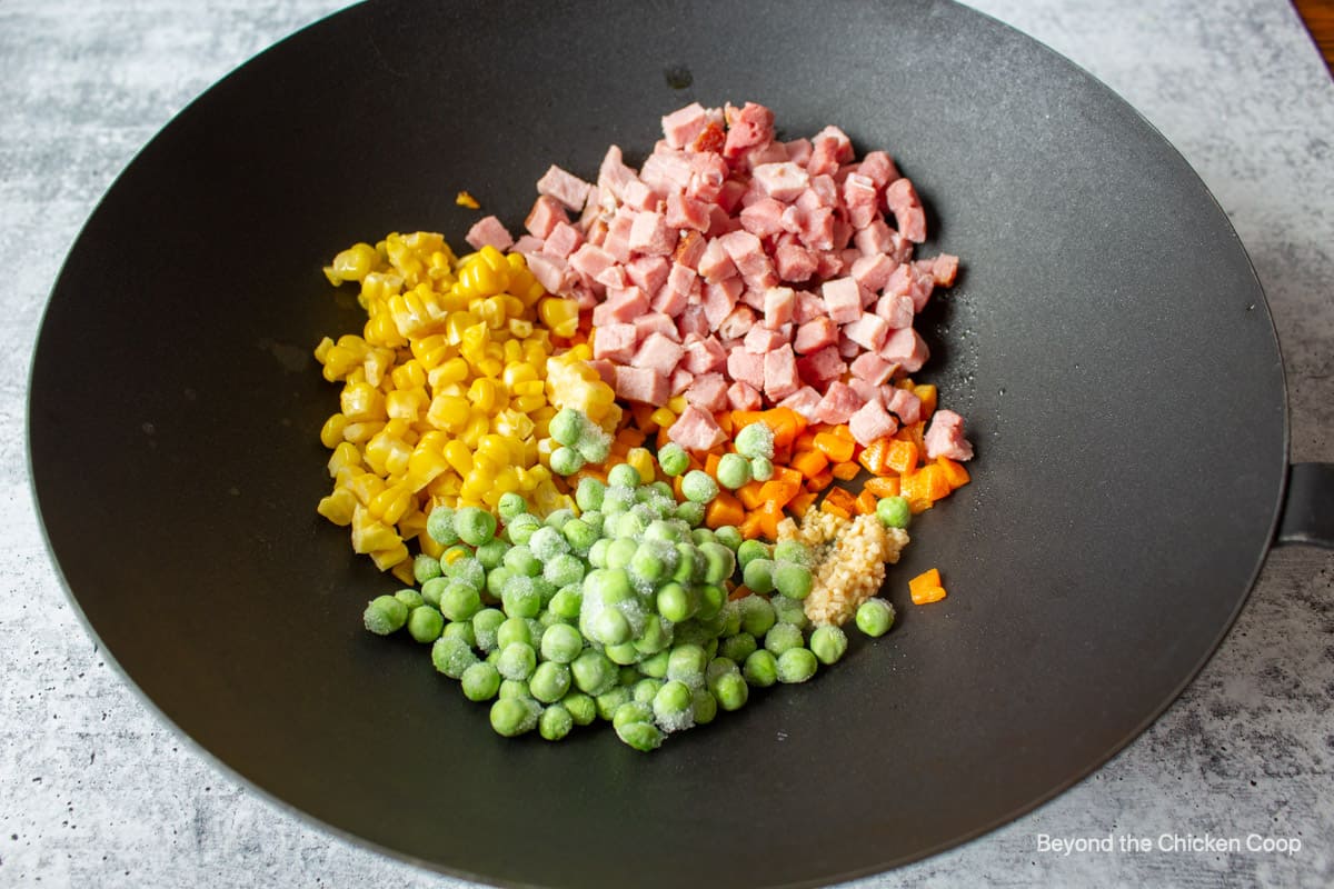 Veggies with diced ham in a wok.