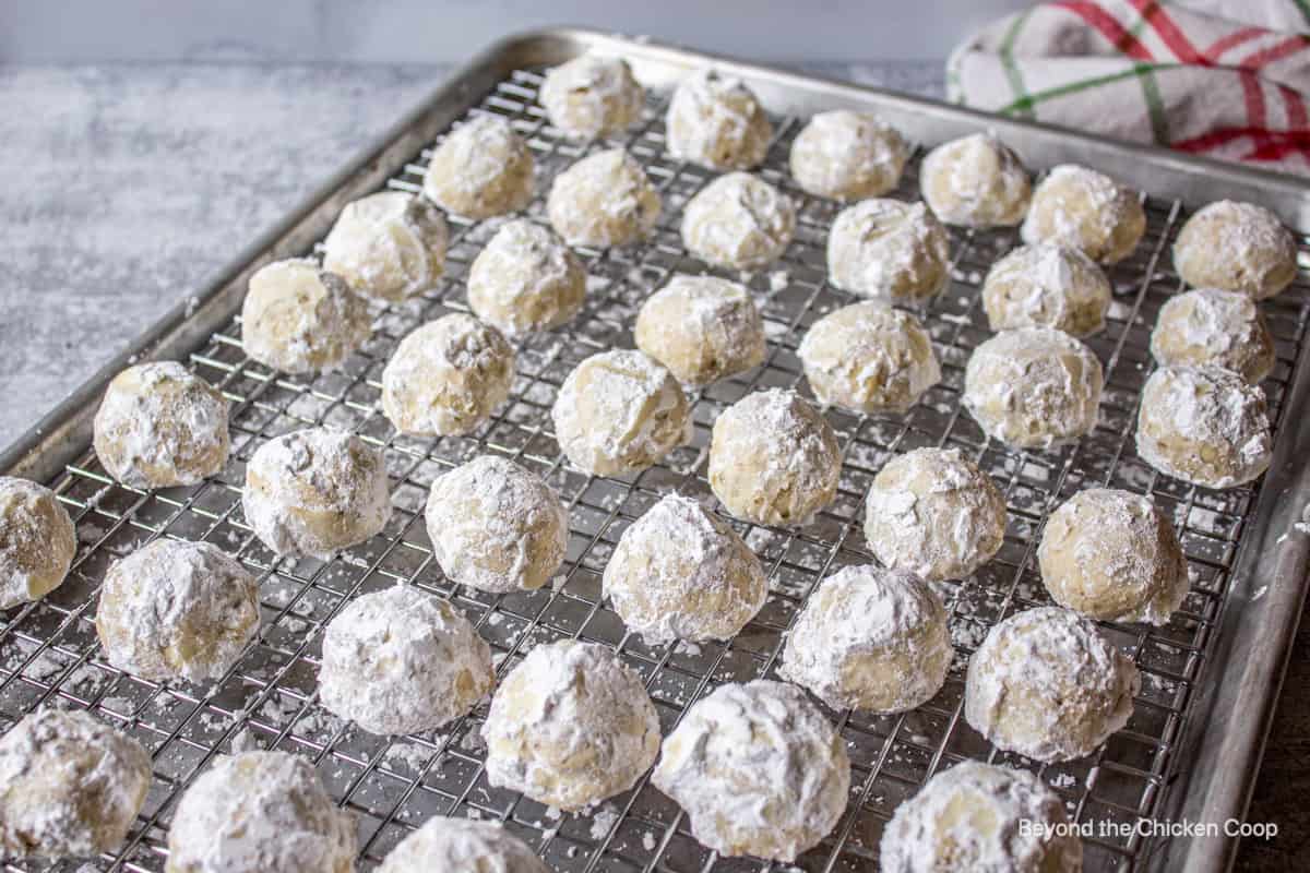 Snowball cookies on a baking rack.