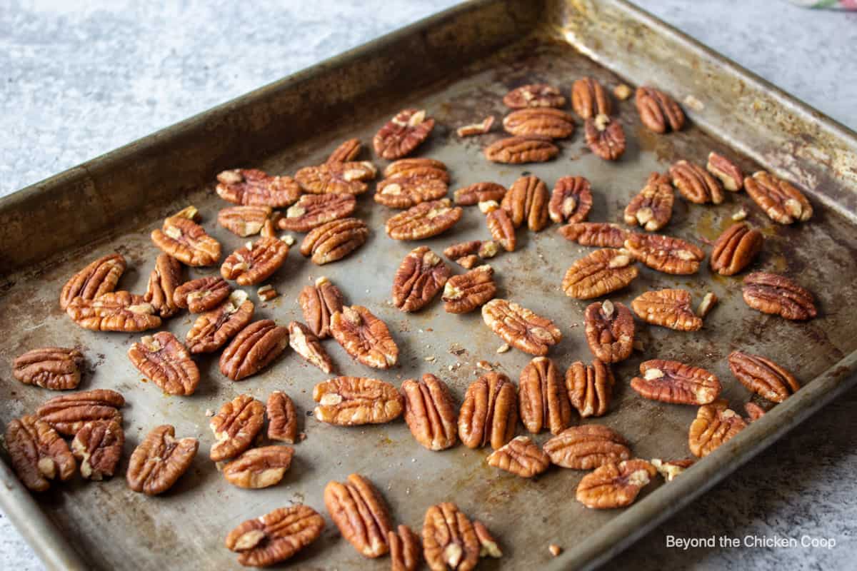 Pecan halves on a baking sheet.