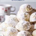 A cake stand piled with round cookies with powdered sugar.