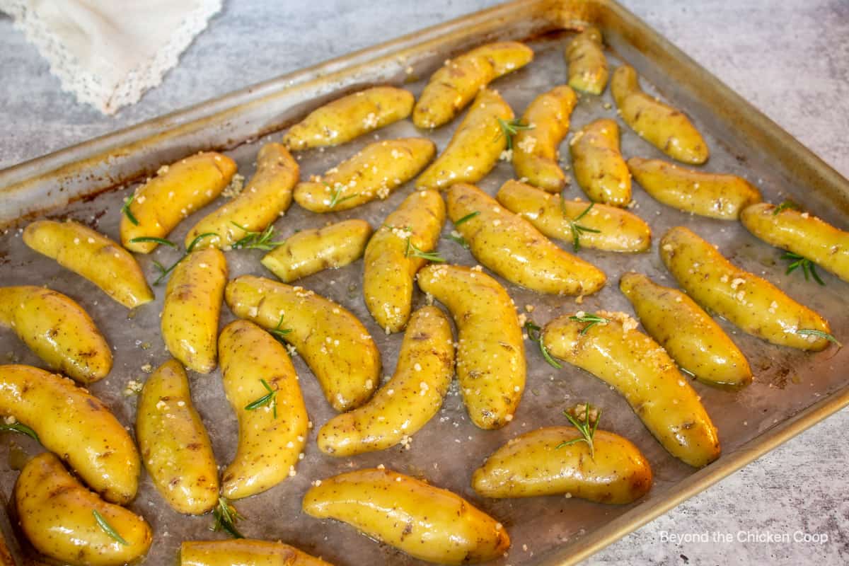 Sliced potatoes on a baking sheet.