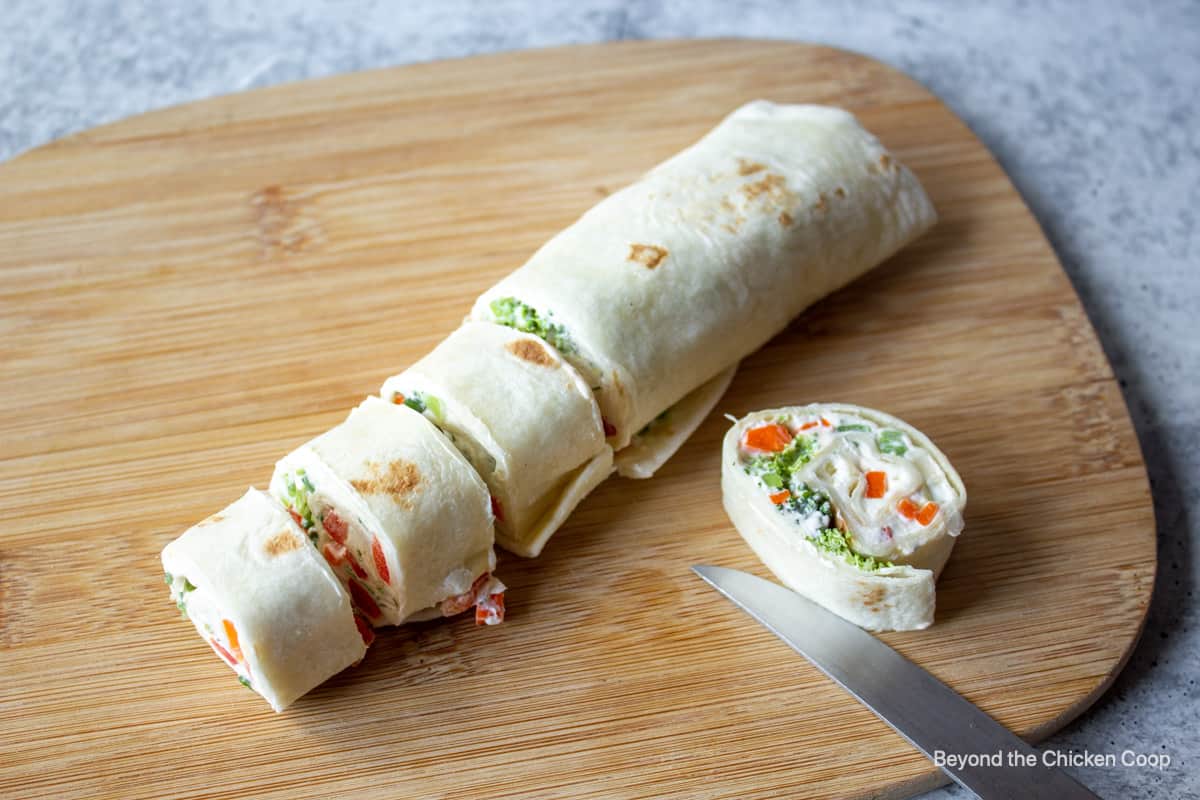 Slicing a veggie wrap into rounds. 