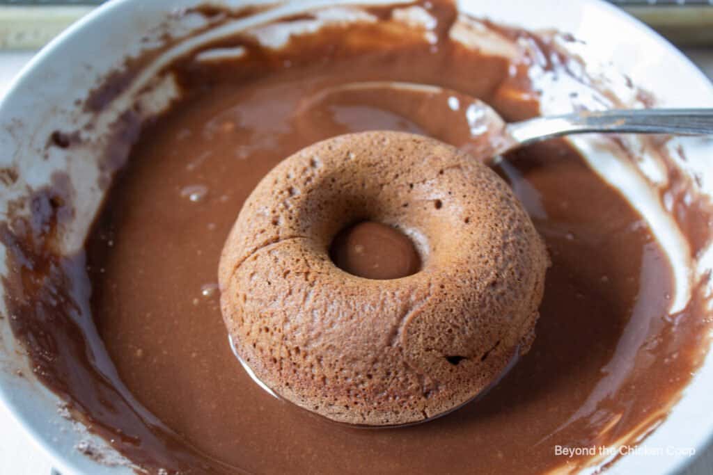 Glaze being added to a donut. 