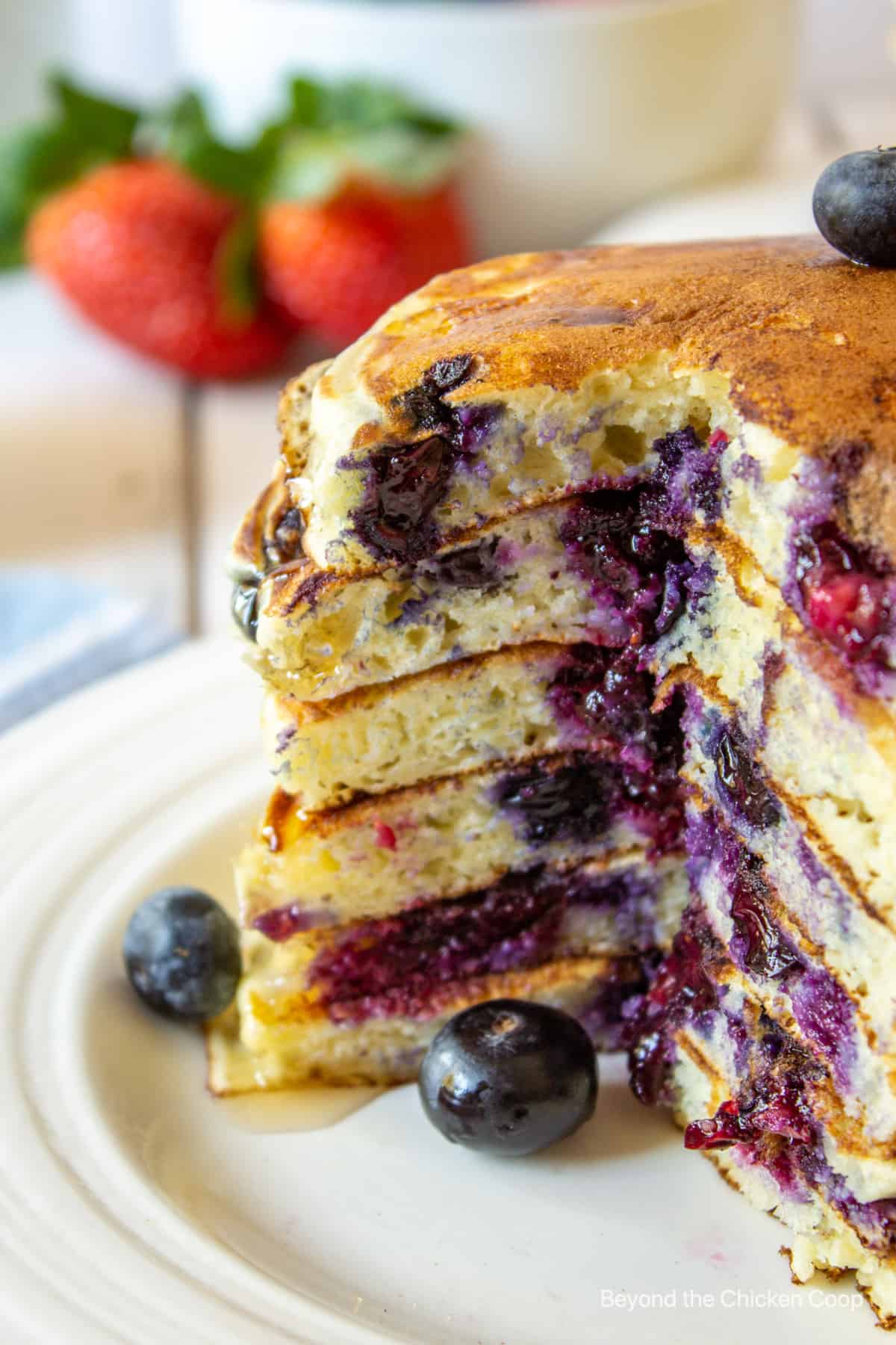 A stack of pancakes filled with blueberries.