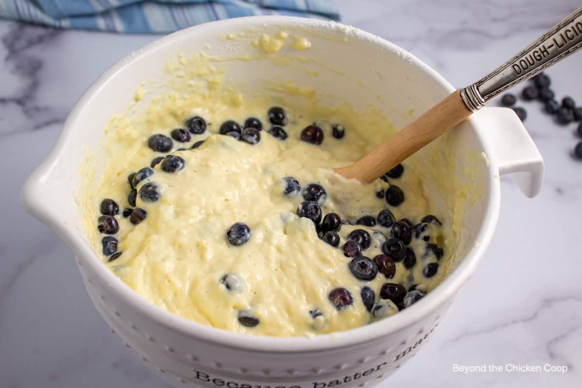 Folding blueberries into pancake batter.
