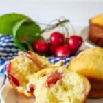 Yellow muffins with red cherries.